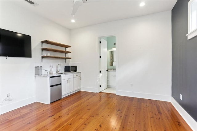 1217 N Tonti St, New Orleans, LA 70119 - kitchen featuring appliances with stainless steel finishes, light wood-type flooring, open shelves, white cabinets, and recessed lighting