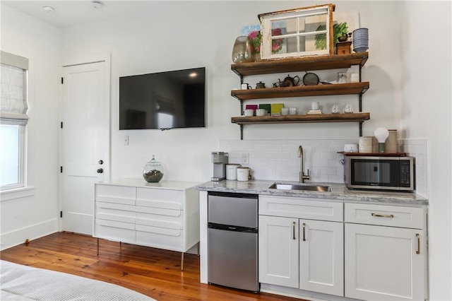 1217 N Tonti St, New Orleans, LA 70119 - bar featuring appliances with stainless steel finishes, tasteful backsplash, and wood finished floors