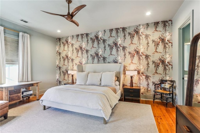 1217 N Tonti St, New Orleans, LA 70119 - bedroom with an accent wall, wallpapered walls, wood finished floors, recessed lighting, and ceiling fan