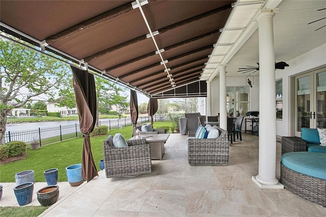 view of patio / terrace featuring fence, french doors, a water view, ceiling fan, and outdoor lounge area
