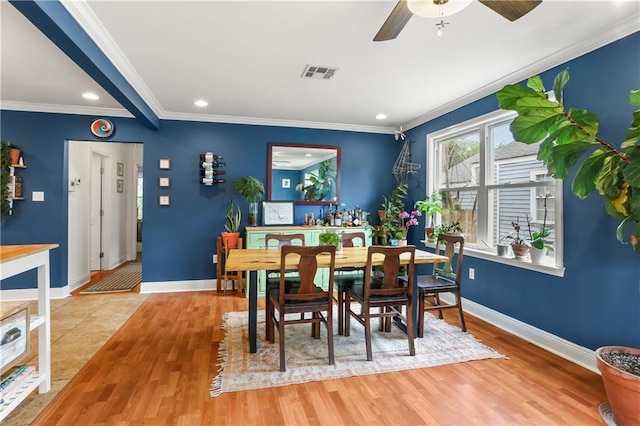4634 Frenchmen St, New Orleans, LA 70122 - dining space with baseboards, visible vents, crown molding, and wood finished floors