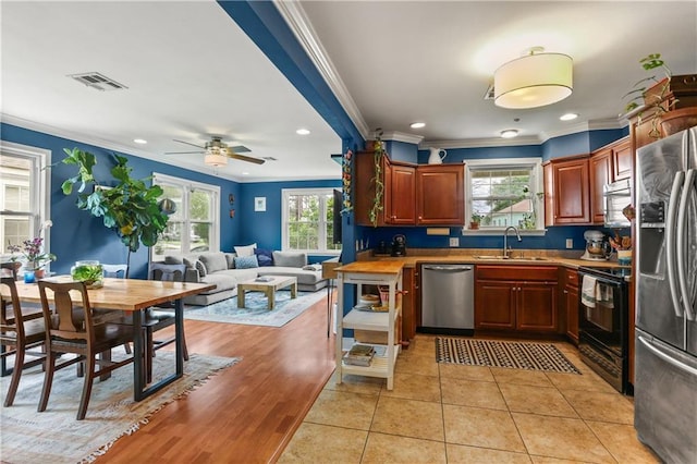 4634 Frenchmen St, New Orleans, LA 70122 - kitchen featuring visible vents, stainless steel appliances, a sink, open floor plan, and light tile patterned floors