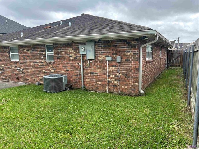 3404 Veronica Dr, Chalmette, LA 70043 - back of property with central AC, roof with shingles, and brick siding
