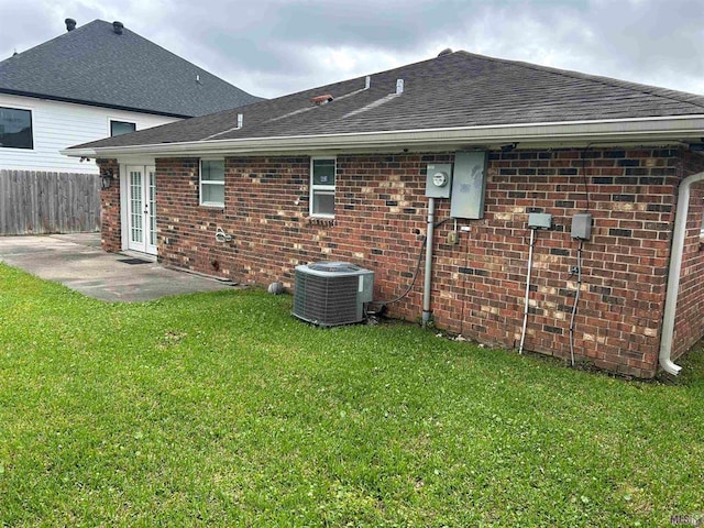 3404 Veronica Dr, Chalmette, LA 70043 - rear view of house featuring brick siding, roof with shingles, cooling unit, and a patio area