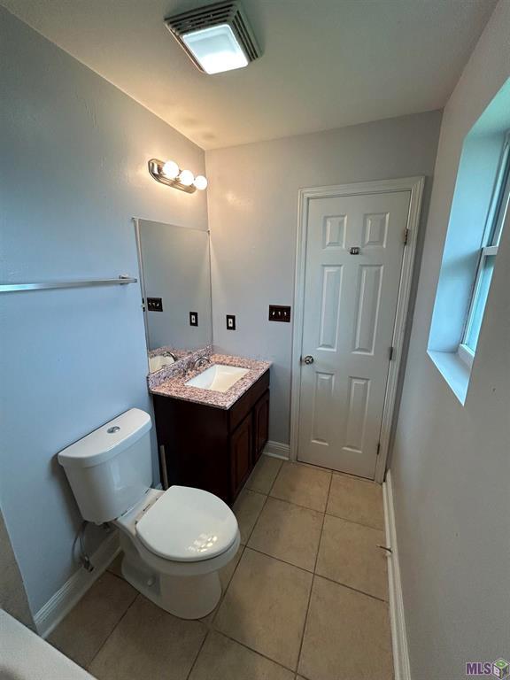 3404 Veronica Dr, Chalmette, LA 70043 - bathroom with tile patterned flooring, vanity, toilet, and baseboards