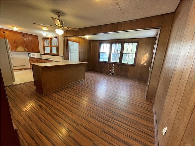 65 Willow Dr, Gretna, LA 70053 - kitchen featuring dark wood finished floors, white appliances, brown cabinetry, and a textured ceiling
