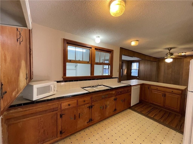 65 Willow Dr, Gretna, LA 70053 - kitchen with tile counters, white appliances, light floors, a sink, and brown cabinetry