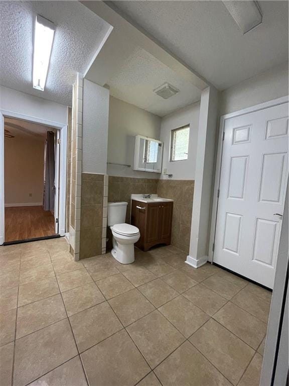 65 Willow Dr, Gretna, LA 70053 - bathroom with tile walls, a textured ceiling, toilet, tile patterned floors, and vanity
