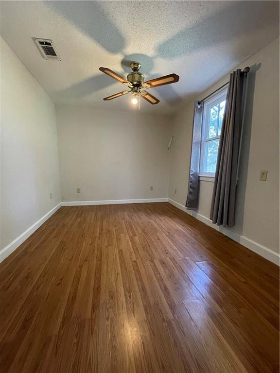 65 Willow Dr, Gretna, LA 70053 - unfurnished room featuring a ceiling fan, wood finished floors, baseboards, and visible vents