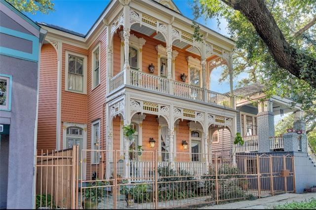 view of front facade with a balcony, a porch, and fence