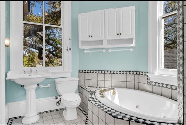 full bath with toilet, a jetted tub, and tile patterned flooring