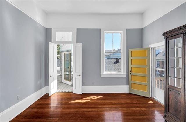 interior space featuring baseboards, a wealth of natural light, and wood finished floors