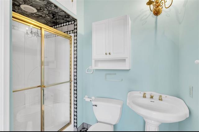 full bath featuring a shower stall, toilet, and a sink