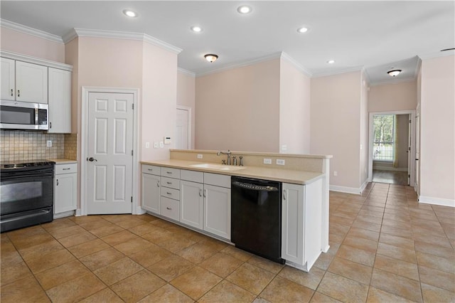 kitchen featuring light countertops, a sink, black appliances, a peninsula, and tasteful backsplash