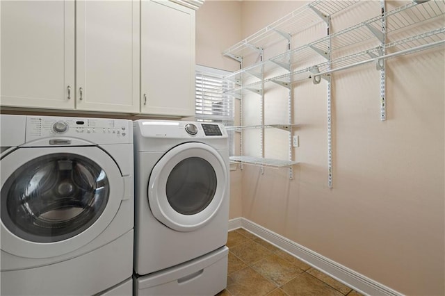 washroom with washing machine and dryer, baseboards, tile patterned flooring, and cabinet space