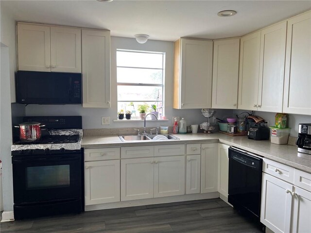 209 10th St, Bridge City, LA 70094 - kitchen featuring black appliances, a sink, dark wood-type flooring, and light countertops
