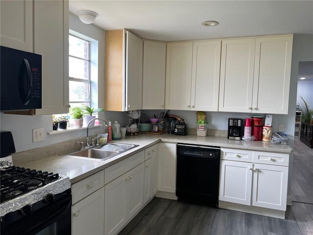 209 10th St, Bridge City, LA 70094 - kitchen featuring white cabinets, light countertops, wood finished floors, a sink, and black appliances