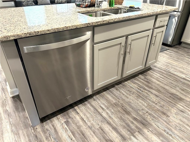 5345 Fulvetta Falls Rd, Slidell, LA 70461 - kitchen featuring dishwasher, light wood-style flooring, a sink, and light stone countertops