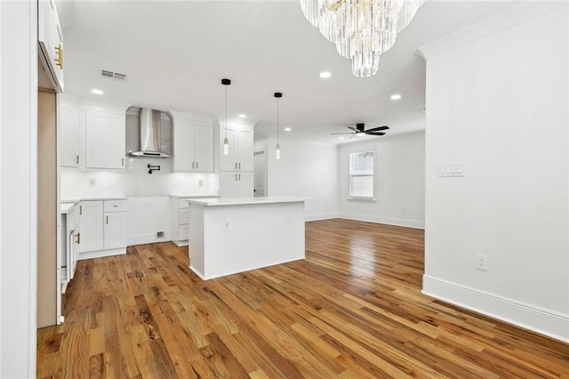 3839 Johnson St, Metairie, LA 70001 - kitchen featuring wall chimney exhaust hood, recessed lighting, light wood finished floors, ceiling fan, and a kitchen island