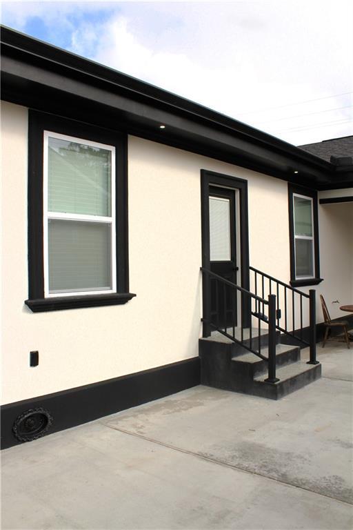 3839 Johnson St, Metairie, LA 70001 - property entrance with stucco siding and a patio area