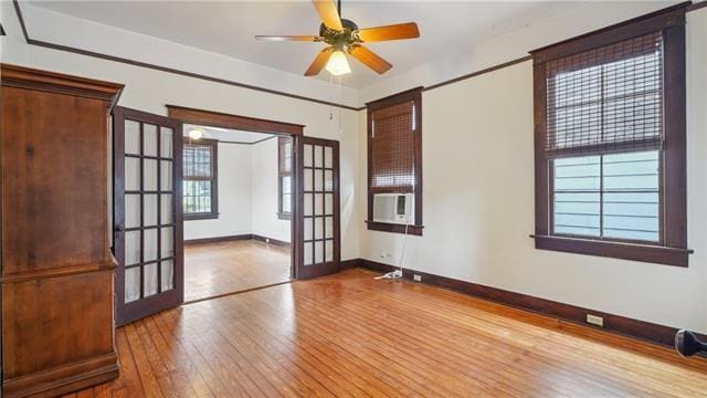 spare room with french doors, a ceiling fan, hardwood / wood-style floors, and baseboards