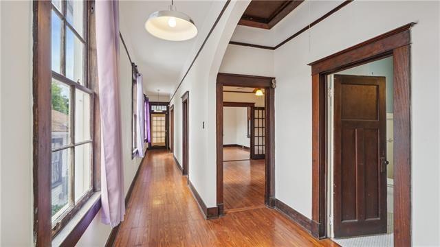 hallway with baseboards, crown molding, and wood finished floors