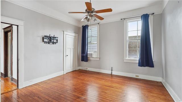 empty room with baseboards, ceiling fan, and wood finished floors