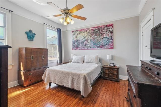 bedroom with baseboards, ceiling fan, and wood finished floors