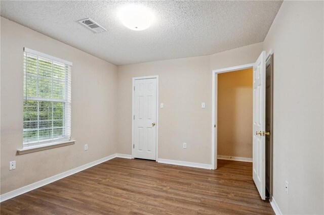441 Parlange Dr, Pearl River, LA 70452 - unfurnished bedroom featuring dark wood-style floors, a textured ceiling, and baseboards