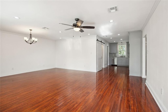 unfurnished living room featuring visible vents, crown molding, recessed lighting, ceiling fan with notable chandelier, and dark wood-type flooring