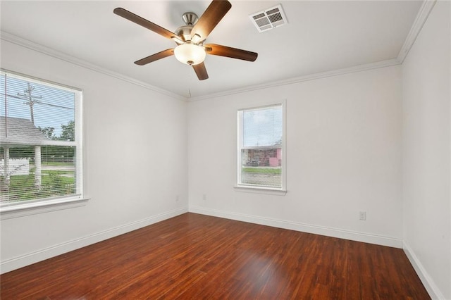 unfurnished room featuring crown molding, wood finished floors, baseboards, and visible vents