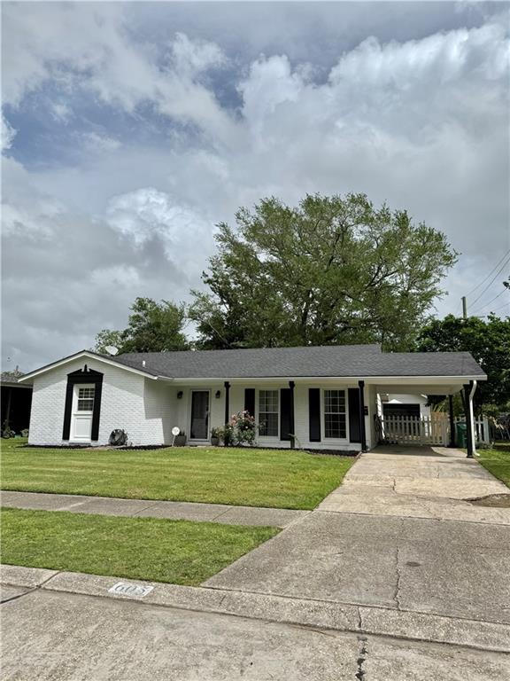 view of front of house with driveway, a front yard, and a carport