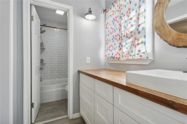 bathroom with toilet, vanity, shower / bathing tub combination, and wood finished floors