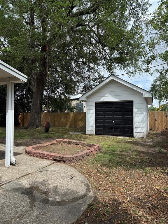 view of yard with an outdoor structure, fence, and a detached garage