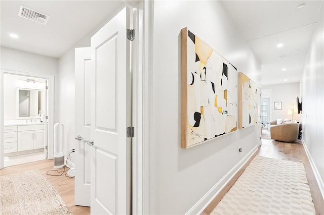 731 St Charles Ave Unit 311, New Orleans, LA 70130 - hallway with recessed lighting, visible vents, a sink, light wood-type flooring, and baseboards