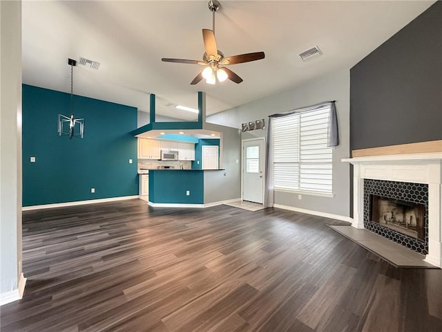 70281 7th St, Covington, LA 70433 - unfurnished living room featuring dark wood finished floors, visible vents, a tile fireplace, and a ceiling fan