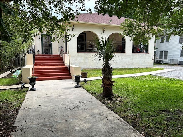 3612 Johnson St, Metairie, LA 70001 - view of front of home with stucco siding, a front lawn, and central AC unit