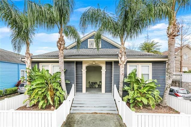 4413 S Liberty St Unit 4413, New Orleans, LA 70115 - bungalow-style house with fence private yard, a shingled roof, and a porch