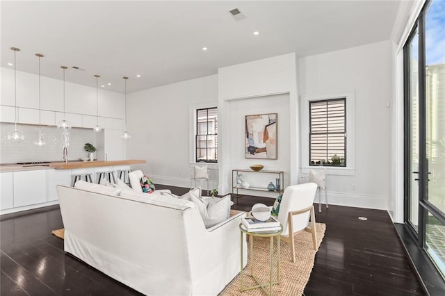 1035 Arabella St, New Orleans, LA 70115 - living area featuring dark wood finished floors, healthy amount of natural light, baseboards, and recessed lighting