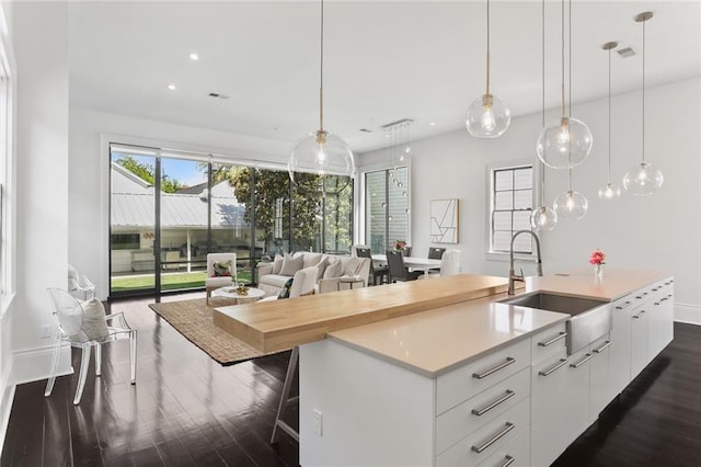 1035 Arabella St, New Orleans, LA 70115 - kitchen with a sink, dark wood finished floors, modern cabinets, a kitchen island with sink, and light countertops