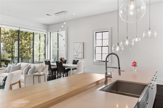 1035 Arabella St, New Orleans, LA 70115 - kitchen with a sink, open floor plan, light countertops, and hanging light fixtures