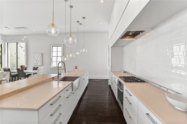 1035 Arabella St, New Orleans, LA 70115 - kitchen with a sink, stainless steel appliances, white cabinetry, dark wood finished floors, and light countertops