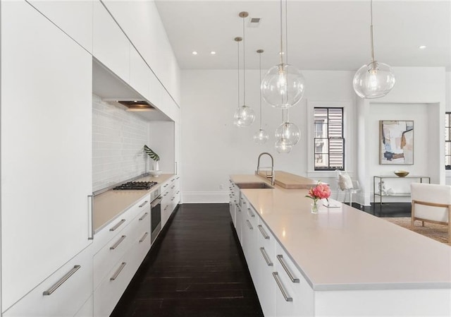 1035 Arabella St, New Orleans, LA 70115 - kitchen featuring a sink, appliances with stainless steel finishes, modern cabinets, white cabinets, and a large island