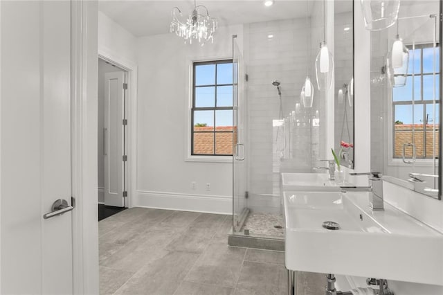 1035 Arabella St, New Orleans, LA 70115 - full bathroom featuring a shower stall, baseboards, a sink, tile patterned floors, and a chandelier