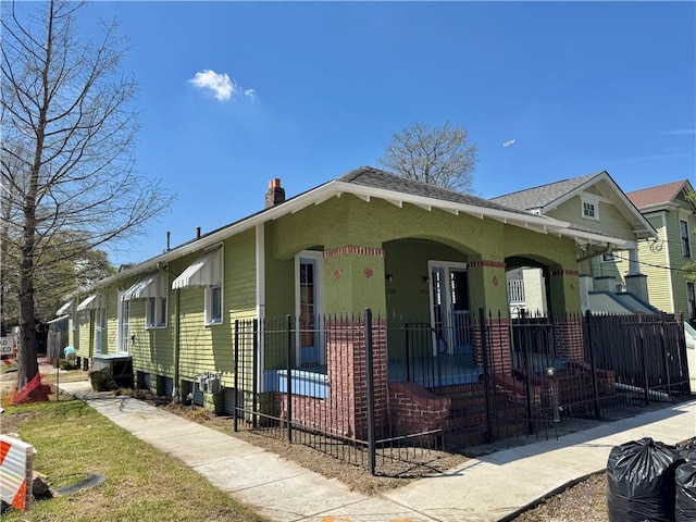 770002 Spruce St, New Orleans, LA 70118 - view of front of home with a chimney, covered porch, and fence