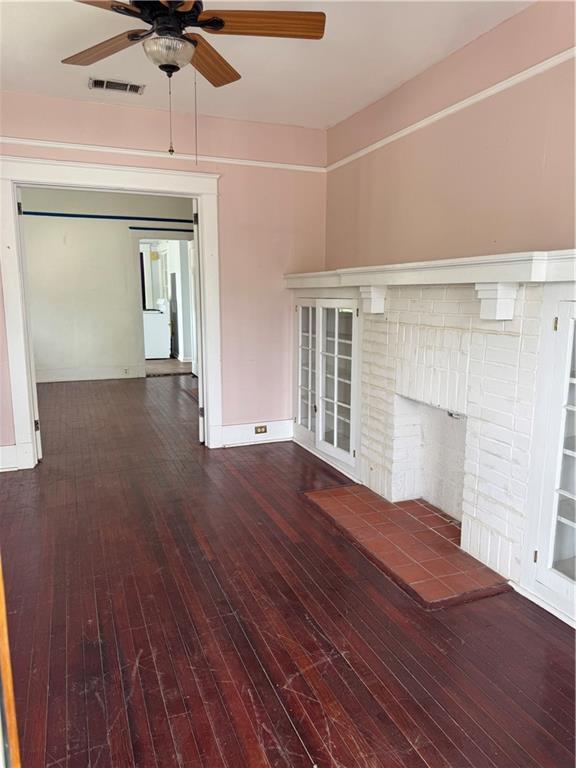 770002 Spruce St, New Orleans, LA 70118 - interior space with wood-type flooring, baseboards, visible vents, a ceiling fan, and a fireplace
