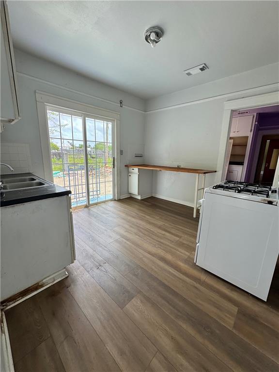 770002 Spruce St, New Orleans, LA 70118 - kitchen featuring visible vents, baseboards, a sink, gas range gas stove, and hardwood / wood-style floors