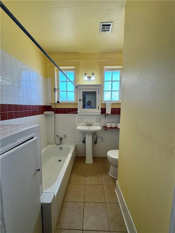 770002 Spruce St, New Orleans, LA 70118 - bathroom with tile patterned floors, toilet, a textured ceiling, and visible vents