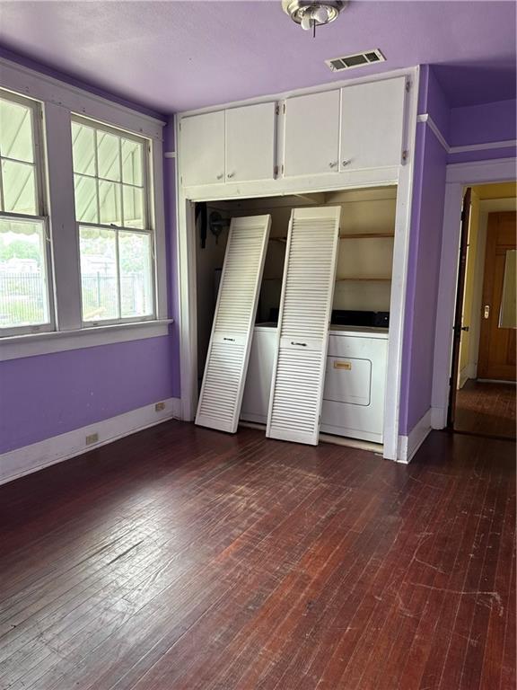 770002 Spruce St, New Orleans, LA 70118 - interior space featuring visible vents, washer / dryer, baseboards, and dark wood finished floors