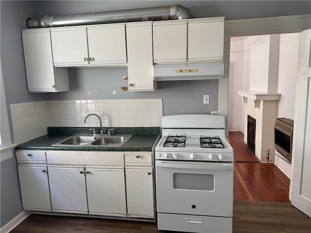770002 Spruce St, New Orleans, LA 70118 - kitchen featuring heating unit, a sink, gas range gas stove, under cabinet range hood, and white cabinets